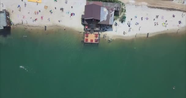 Vista aérea de la gente en una playa de arena en el lago — Vídeos de Stock