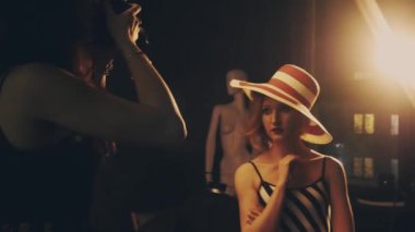 Stüdyoda bir kadın fotoğraf mankeni çekiyor.