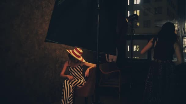 Fotograf fotografera en kvinnlig fotomodell i en studio — Stockvideo