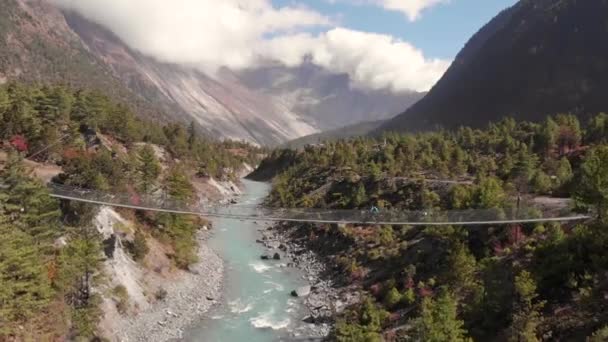 Mountain bikers crossing a swinging bridge in Nepal. — Stock Video