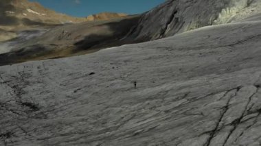 Elbrus bölgesindeki Buzul 'da koşan bir grup insan üzerinde havadan uçuş.