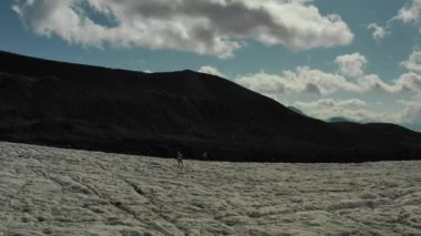 Elbrus bölgesindeki Buzul 'da koşan bir grup insan üzerinde havadan uçuş.