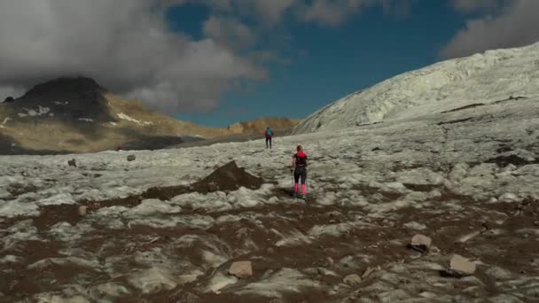 Vuelo aéreo sobre el grupo de personas que corren en el glaciar en la región de Elbrus. — Vídeo de stock