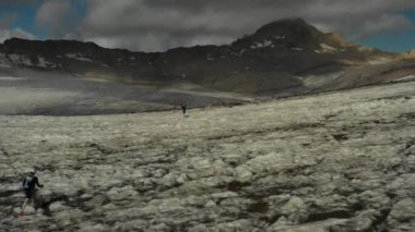 Elbrus bölgesindeki Buzul 'da koşan bir grup insan üzerinde havadan uçuş.