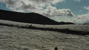 Elbrus bölgesindeki Buzul 'da koşan bir grup insan üzerinde havadan uçuş.