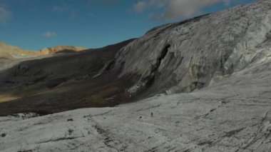Elbrus bölgesindeki Buzul 'da koşan bir grup insan üzerinde havadan uçuş.