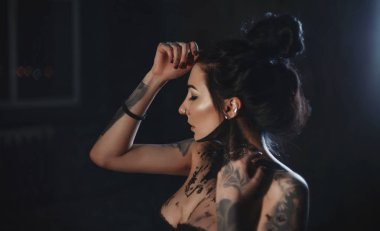 Elini yüzünü yakınındaki boya tutan bir dövme ile bir sanatçı