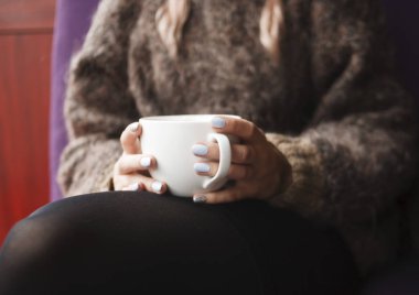 Çay fincan iki ellerini tutar