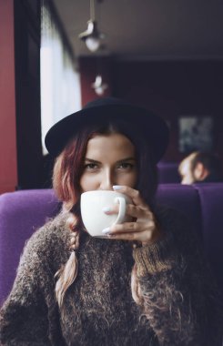 Bir kafede çay fincan her iki ellerini tutar