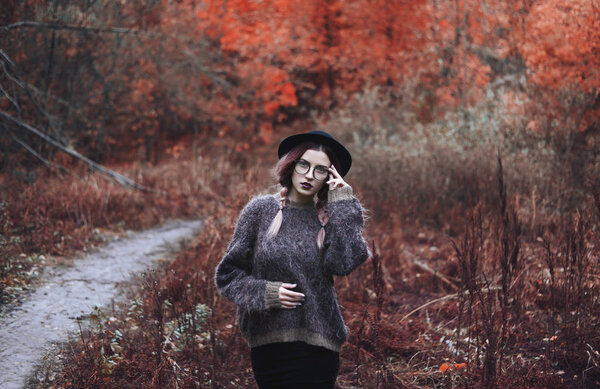Portrait of a girl in a coat, glasses in the woods