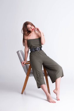 Kız stüdyoda bir sandalyede oturuyor