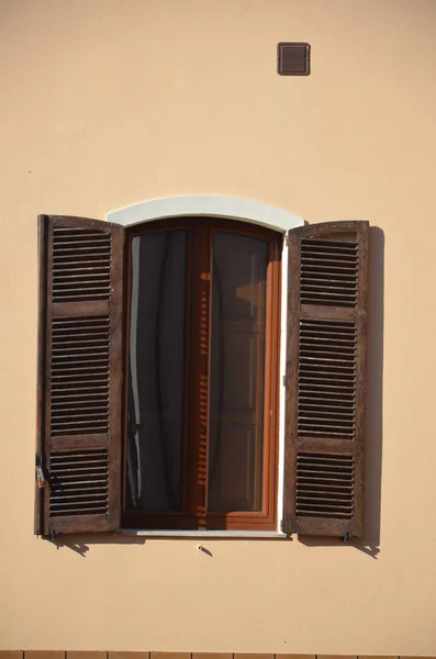 Window with brown wooden shutters