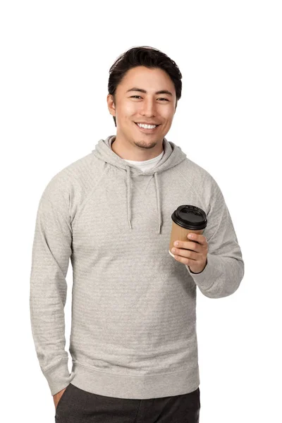 0多岁的迷人男人站在白色的背景下 穿着灰色的头套衬衫微笑着 拿着一个外卖的杯子咖啡杯 看着镜头 — 图库照片