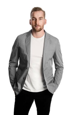 Sakallı, şık, yakışıklı bir İskandinav. Kameraya ciddi ciddi bakıyor. Üzerinde de elleri cebinde güzel bir ceket var..