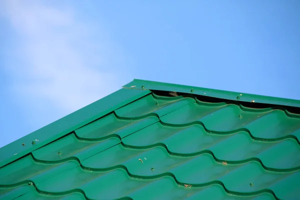 Yeşil modern çatı kiremit etkisi ile Pvc kaplı metal çatı sayfaları mavi gökyüzü karşı kaplı.