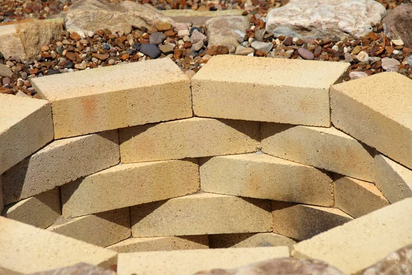 Sarı aluminous tuğla ve çakıl yaz bahçesinde çevrili kayalar ateş çukuru yapılmış
