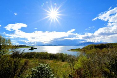 İskoçya Highlands bulutlar ve mavi gökyüzü yeşil çim güneş peyzaj göl