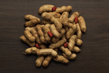 Fıstık kahverengi ahşap zemin üzerinde. Bir avuç fındık