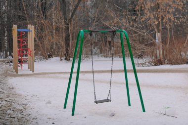 Kışın boş salıncak. Karda salıncak. Çocuk Bahçesi boş