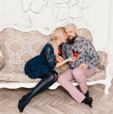 Güzel çift kanepede oturan aşık. bir adam bir kızı öper. Aşıklar birbirlerine kalplerini vermek. Aşıklar hugs.