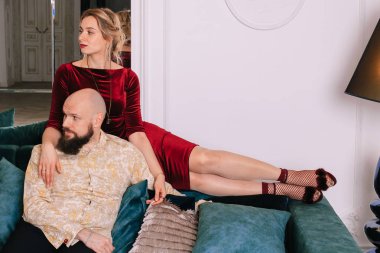 Güzel çift kanepede parlak bir odada aşık. Bir adam ve bir kadın büyük kanepede oturuyordu.