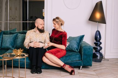 Genç çift evdeki kanepede oturuyor.