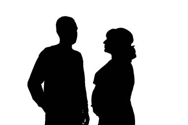Hamile bir kadın ve bir erkek. Beyaz arka planda siyah siluetler. İzolasyonda
