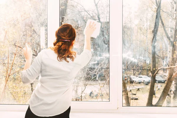 Молодая женщина моет окна — стоковое фото