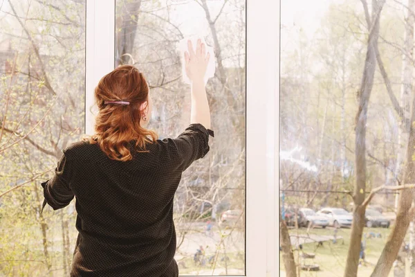 Junge Frau beim Fensterputzen — Stockfoto