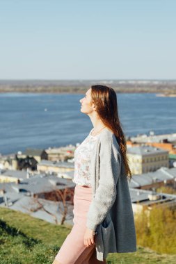 Sakin güzel gülümseyen genç kadın açık havada temiz hava zevk, gözleri kapalı rahatlatıcı, canlı duygu.