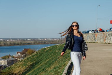 Genç bir kız şehir koyunda set üzerinde yürüyor.