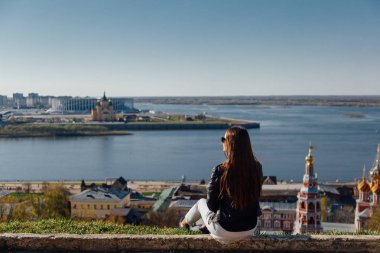 Genç bir kız şehir koyunda set üzerinde yürüyor.