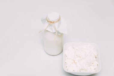 Beyaz arka planda şişeve süzme peynir süt