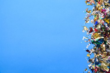 Mavi arka planda uçan renkli konfeti