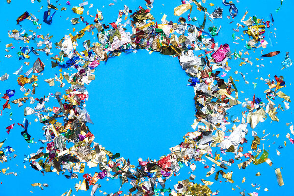 Colored confetti flying on blue background