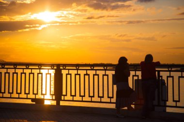 İki arkadaş şehir dolgu üzerinde gün batımı hayran.