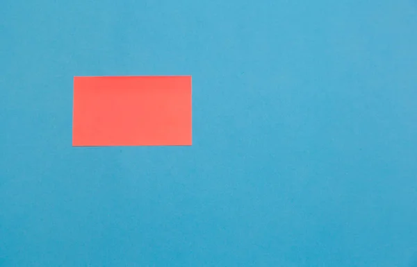 Pegatinas cuadradas de papel vacías de color rosa sobre fondo azul, espacio de copia — Foto de Stock