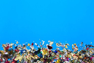 Tatil çerçevesi mavi pastel arka plan üzerinde gümüş tinsel ve köpüklü konfeti yapılır. Şenlikli konsept.