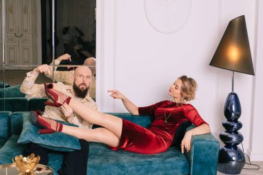 Kırmızı ayakkabılarla bir kadının ayağını öpen yakışıklı bir adam