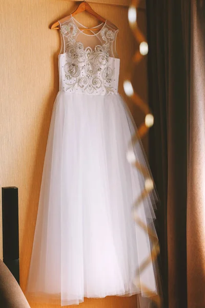 O vestido de noiva perfeito com uma saia cheia em um cabide no quarto da noiva — Fotografia de Stock