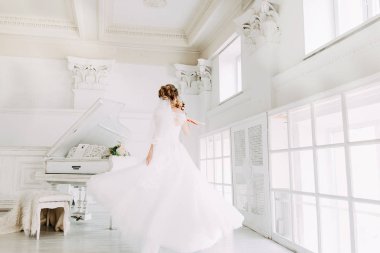 Güzel çekici gelin gelinlik uzun tam etek, beyaz arka plan ile dans ve gülümse