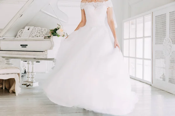 Bella sposa attraente in abito da sposa con gonna lunga completa, sfondo bianco, danza e sorriso — Foto Stock