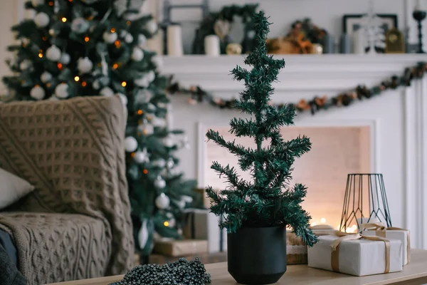 Beautiful holiday decorated room with Christmas tree, fireplace and armchair with blanket.