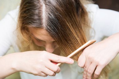 Gri olacak. Kadın beyaz saç köklerini gösteriyor. Kapat.