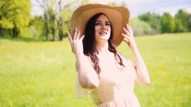 Art Village otantik güzellik retro bayanı, doğanın çiçek açan sarı alanının tadını çıkarın. Uyum kavramı. Uzun, beyaz, klasik bohem gelinlik treni. Hasır şapka kayıkçı çiçekler.