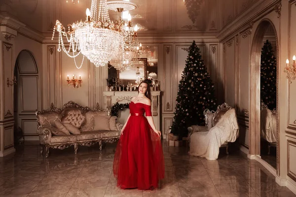 Noel partisi sahnesi, muhteşem kırmızı elbiseli kadın, modaya uygun bir konsept. Lüks Noel Salonu