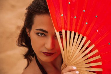 Çölde kızıl yelpazeli bir kadın. Portre yakın çekim