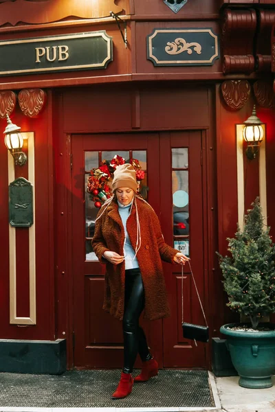 Happy woman leaves the pub. The Christmas weekend. Happy new year\'s days.
