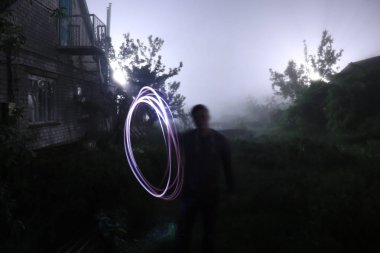 Garip adamın figürü açık havada sis arka plan ile karanlıkta ışık ile boyama