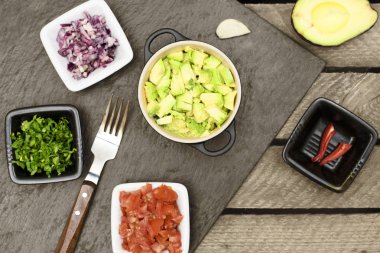 Guacamole için malzemeler: avokado, limon, domates, soğan ve kişniş